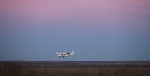 Small Airplane Landing on Rural Airstrip at Dusk