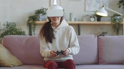 Woman Playing VR Game on Couch at Home