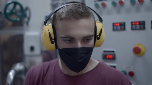 Caucasian Guy Working In Beer Factory Wearing Noise Reduction Ear Muff And Facemask