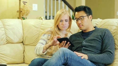 Couple Using Tablet on Comfortable Couch