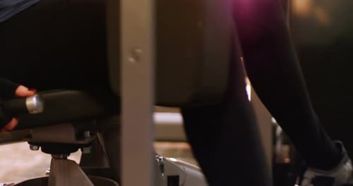 Woman Exercising Legs on Leg Press Machine at Gym