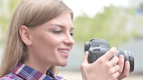 Woman Photographer with Camera Smiling Outdoors in City