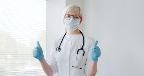 Healthcare Worker Gives Two Thumbs Up in Hospital