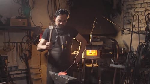 Blacksmith Works with Metal on Anvil in Forge. Slow Motion