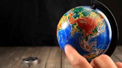 Mit dem Finger auf den Globus zeigen