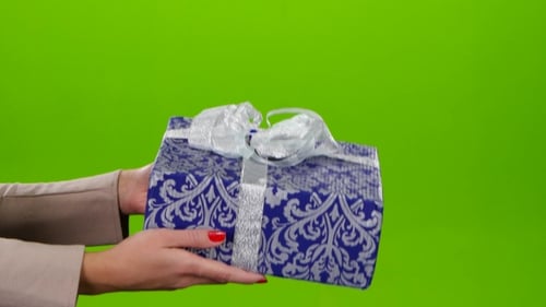 Woman Presents Gift Wrapped in Blue on Green Screen