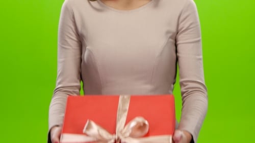 Person Holding Red Gift Box on Green Screen
