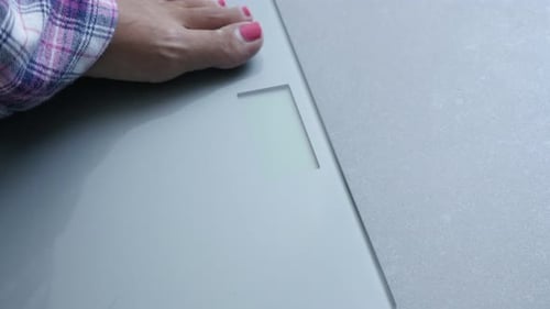 Woman morning weight measuring in pajamas close-up 4K 2160p 30fps UHD footage - Digital health scale