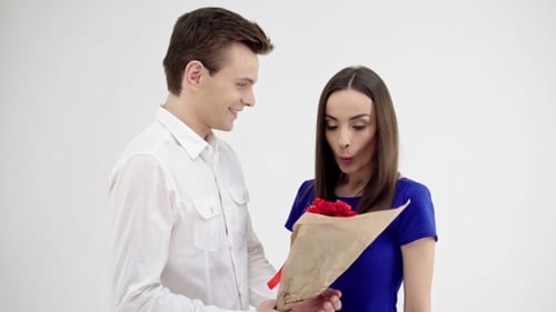 Young Couple Exchange Romantic Gift of Red Roses