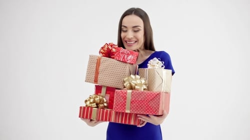 Smiling Woman Holding Stack of Beautifully Wrapped Gifts