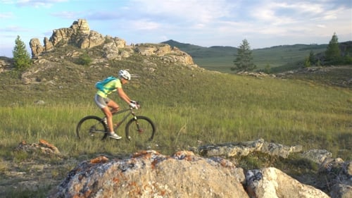 Biking Woman Cycling on Green Meadow