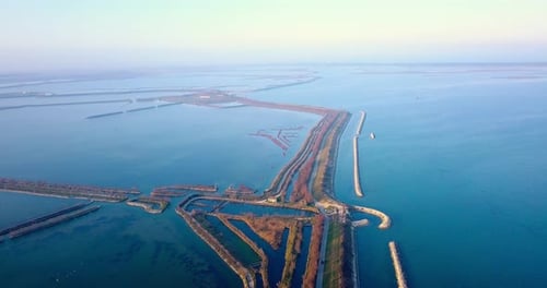 Small Asphalt Road with Cars Among Endless Calm Blue Lagoon