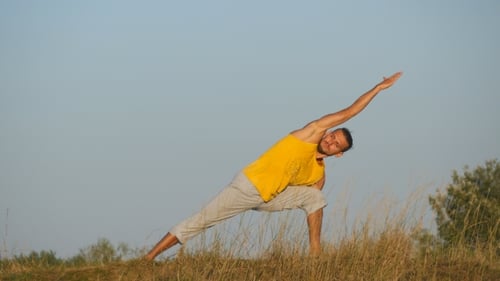 Caucasian Guy Practicing Yoga Moves and Positions in Nature. Young Sporty Man Standing at Yoga Pose