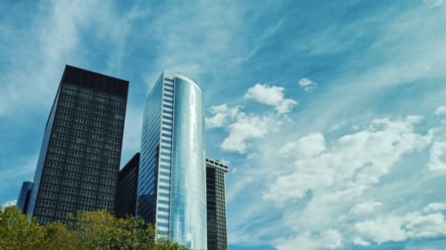Two Modern Office Buildings Against the Sky and Clouds Drifting Fast. The Business District of