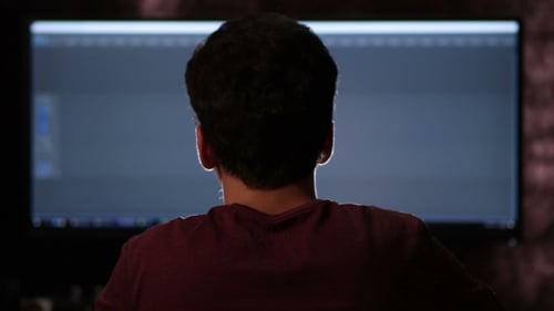 Rückansicht eines Mannes, der am Breitbildcomputer arbeitet