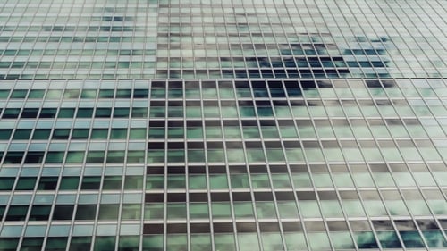 Glass Windows of the Building, They Are Reflected Quickly Floating Clouds