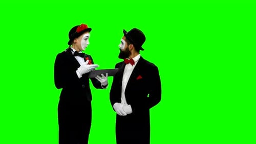 Dos memes discuten algo usando una tableta en pantalla verde