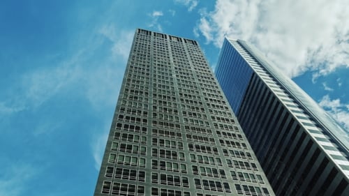 Two Modern Office Buildings Against the Sky and Clouds Drifting Fast.