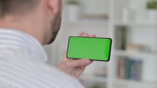 Rear View of Young Man Watching Smartphone with Chroma Screen