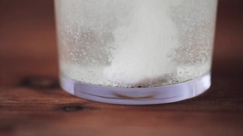 Effervescent Tablet Dissolving in Glass of Water