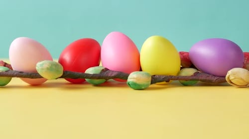 Osterkonzept mit mehrfarbigen Eiern und Blumen auf dem Tisch