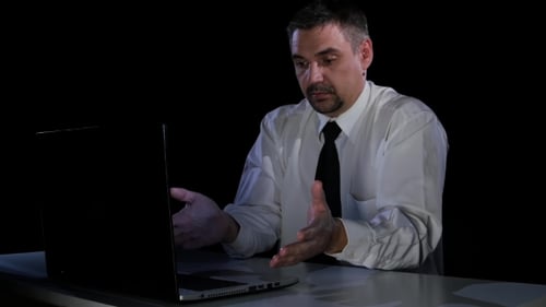 Man in Confusion Communicates with the Chief on the Laptop