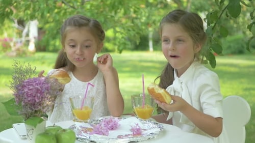 The Cute Girls Eating the Donuts in the Garden