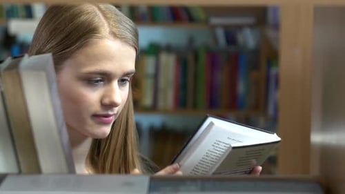 Pretty Young Girl Chooses a Book in the Library. Close Up
