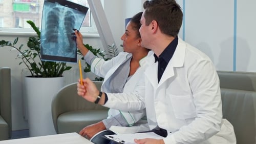 Male Doctor Points on the X-ray at the Hospital