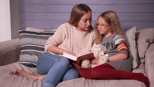 Young Adult Woman Reading Book to a Child