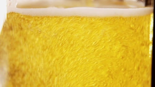 Golden Beer Pouring into Glass with Bubbles