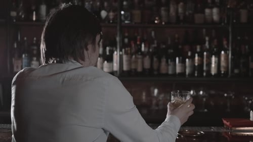 Young Drunk Man Drinking Alcohol in the Bar Alone. Lonely Businessman with Whiskey in Bar at Night