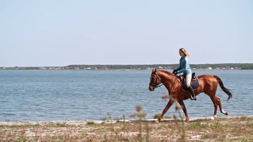 Young Woman Riding Horse near Lake