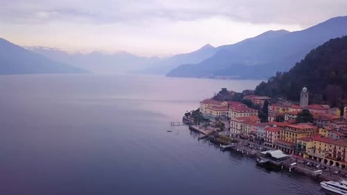 aeraial panning shot of Bellagio in north italy with a view of lake como and the swiss alps in backg