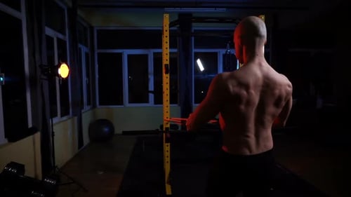 Strong Fitness Man Bodybuilder Training at the Gym Late in the Night