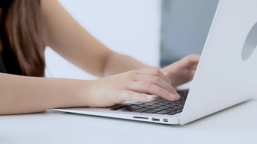 Closeup freelance woman working and typing on laptop computer at desk office.