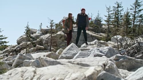 Couple Hiking Down Rocky Mountain Path Together