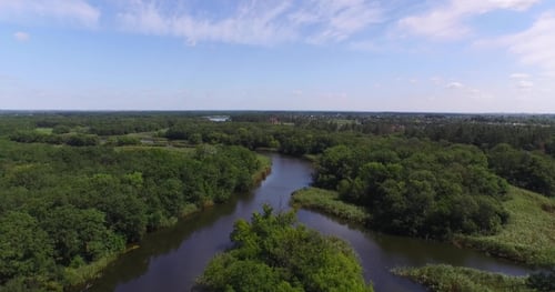 Flying Over a Small River with Tributaries Surrounded By Forest