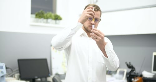 Man Working With Pipette and Vial in Lab