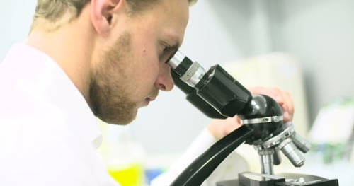 Young Adult Scientist Working with Microscope in Lab