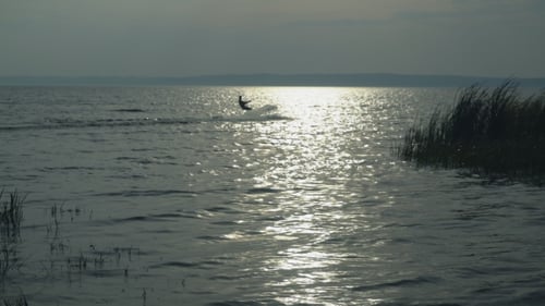 Kitesurfista en el lago en otoño disfruta del deporte extremo
