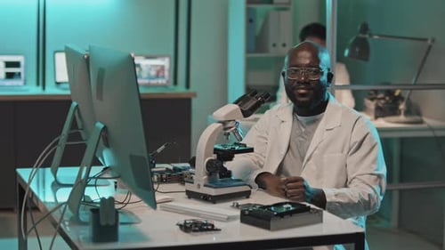 Scientist Looks into Microscope in Lab