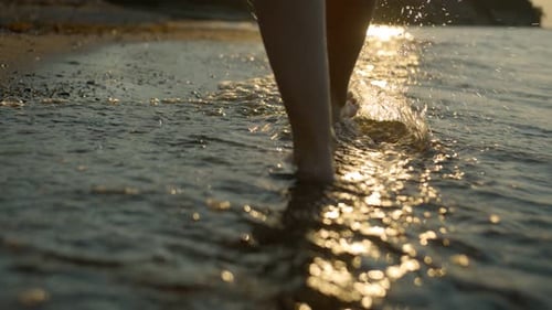 Bare Feet Walking on Beach at Sunset