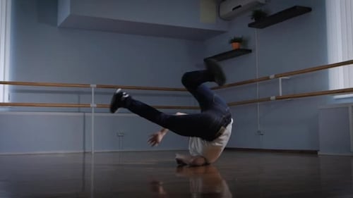 Professional Breakdancer Performs Complex Dance Exercise on the Floor of the Dance Studio. Young Boy
