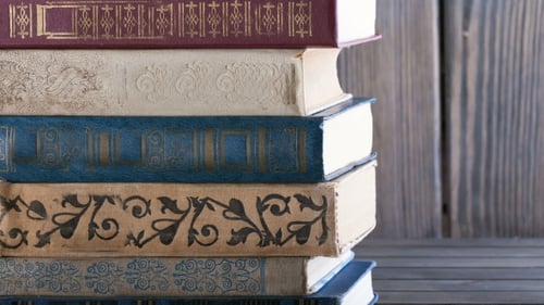 Stack of old books on wooden background