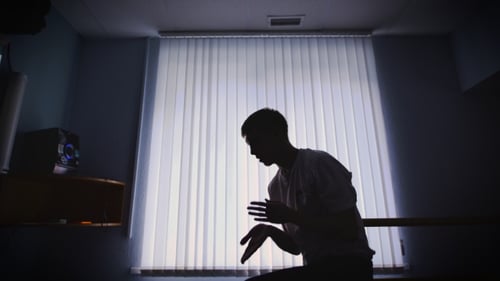 Dancer Dressed in Jeans and White Shirt Dancing Near the Window with Jalousie in Shadowed Room
