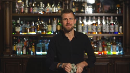 El camarero está limpiando un vaso