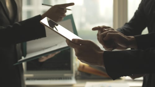 Business Colleagues Consulting Over Documents and Tablet