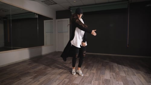 Young Woman Dancing in a Dark Studio