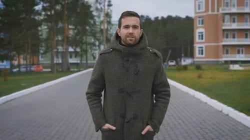 A Handsome Man, Tall Walking Along a Path Near the House. He Wore a Gray Coat and Black Pants